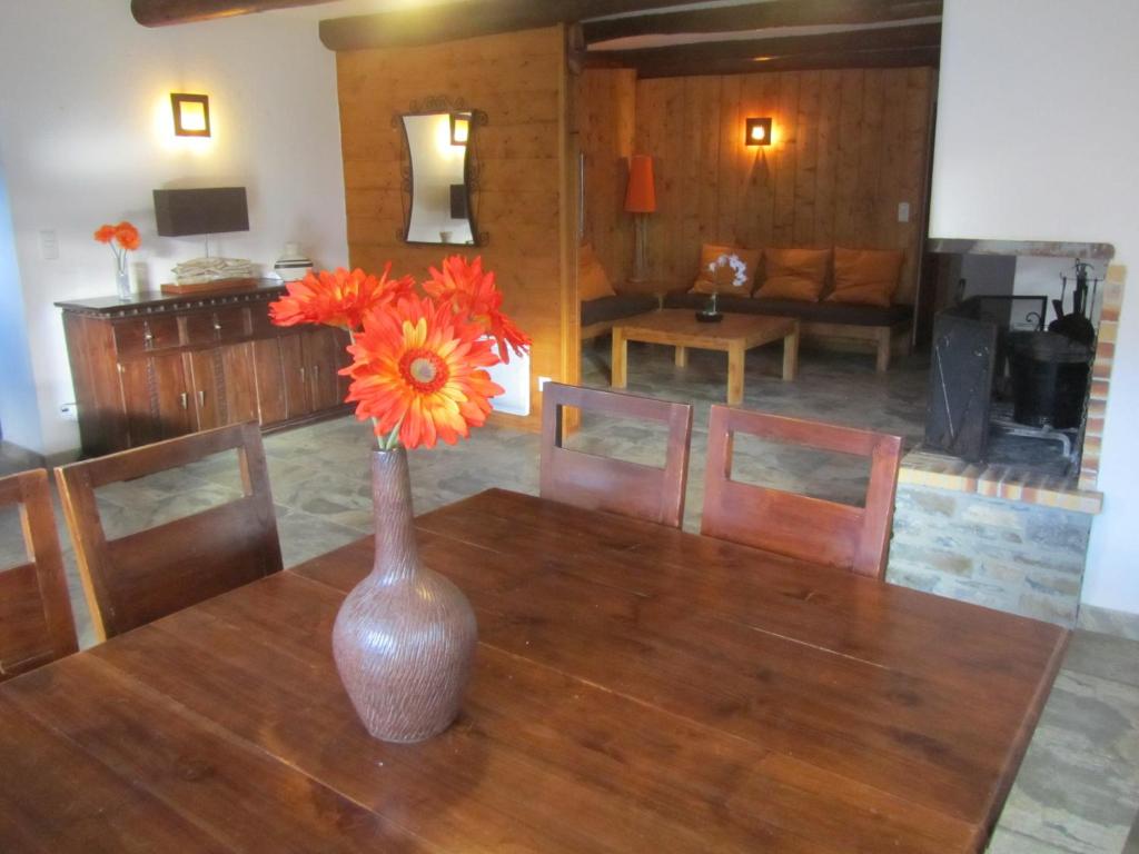 um vaso com flores de laranja numa mesa de madeira em Les GITES DE CAMPARAN - gîte "la BERGERIE AVEC SPA" em Camparan