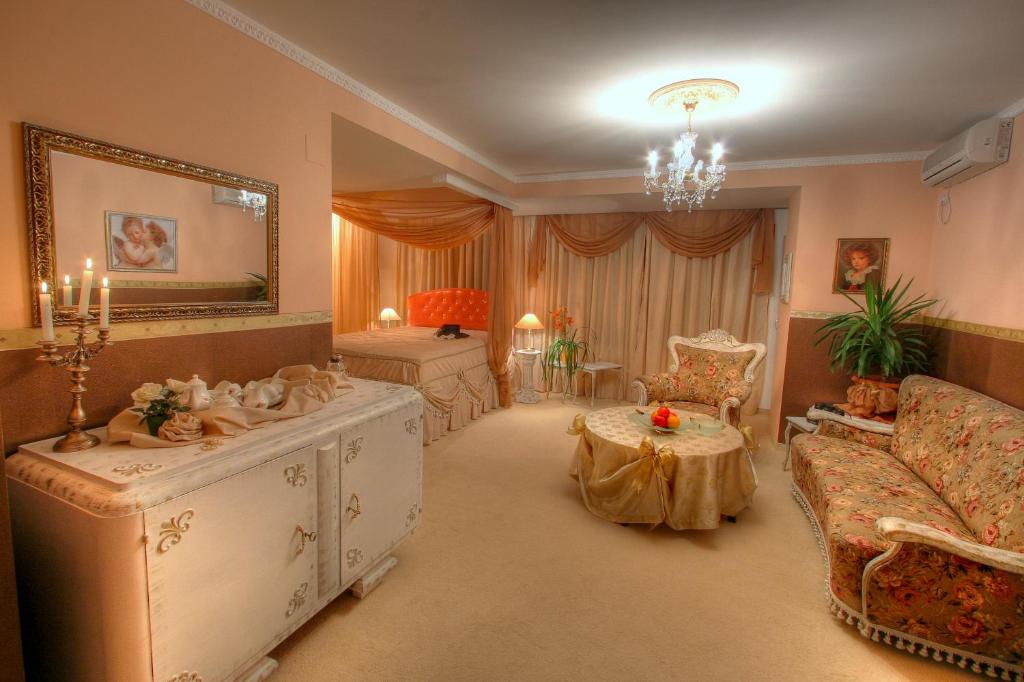 uma sala de estar com um sofá e uma mesa em Family Hotel Mania em Stara Zagora