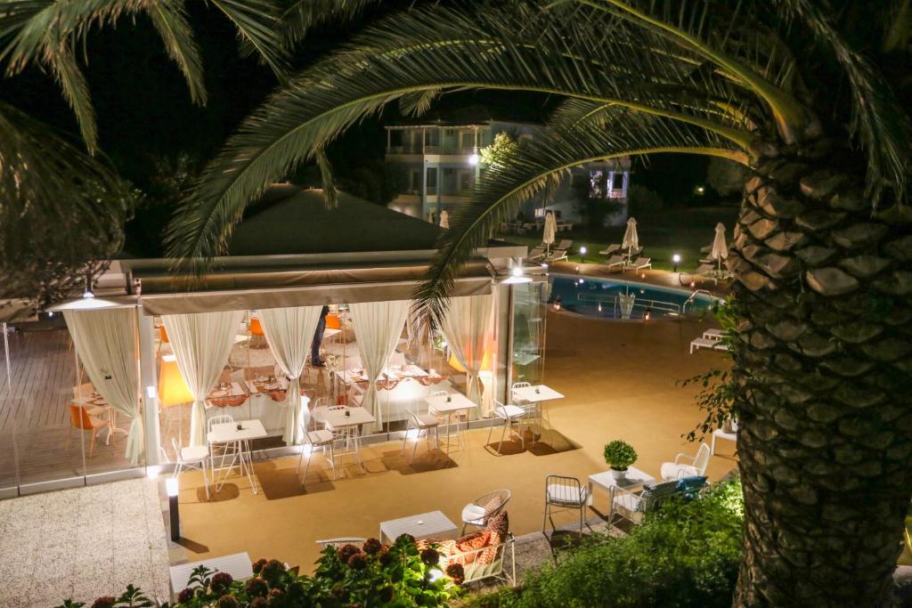 a view of a pool with tables and chairs at night at Mandraki Village Boutique Hotel in Koukounaries