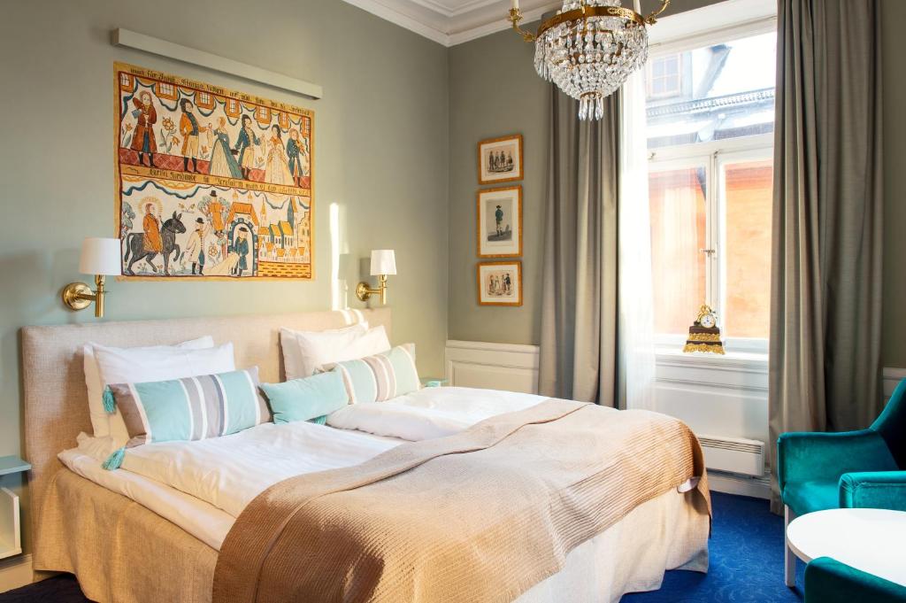 a bedroom with a large bed and a chandelier at Lady Hamilton Hotel in Stockholm