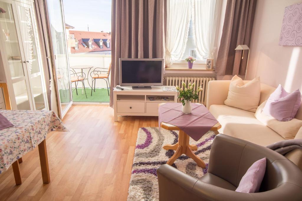 sala de estar con sofá y TV en Ferienwohnungen KUR-ECK en Bad Wörishofen