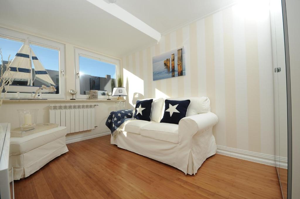 ein Wohnzimmer mit einem weißen Stuhl und einem Fenster in der Unterkunft Exklusiv Wohnung Nika in Westerland