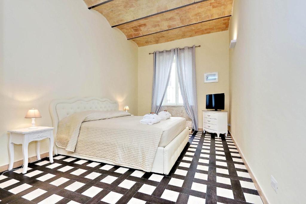 ローマにあるColosseum Suiteの黒と白のチェッカーフロアのベッドルーム1室
