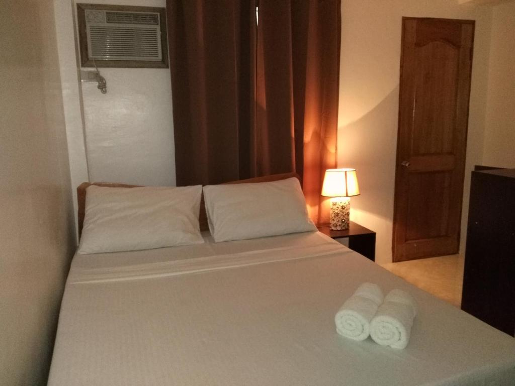 um quarto com uma cama com duas toalhas em Zenith Inn & Resto Bar em Anda
