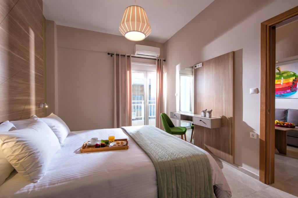 a hotel room with a bed with a tray of food on it at Downtown Central Apartments in Heraklio