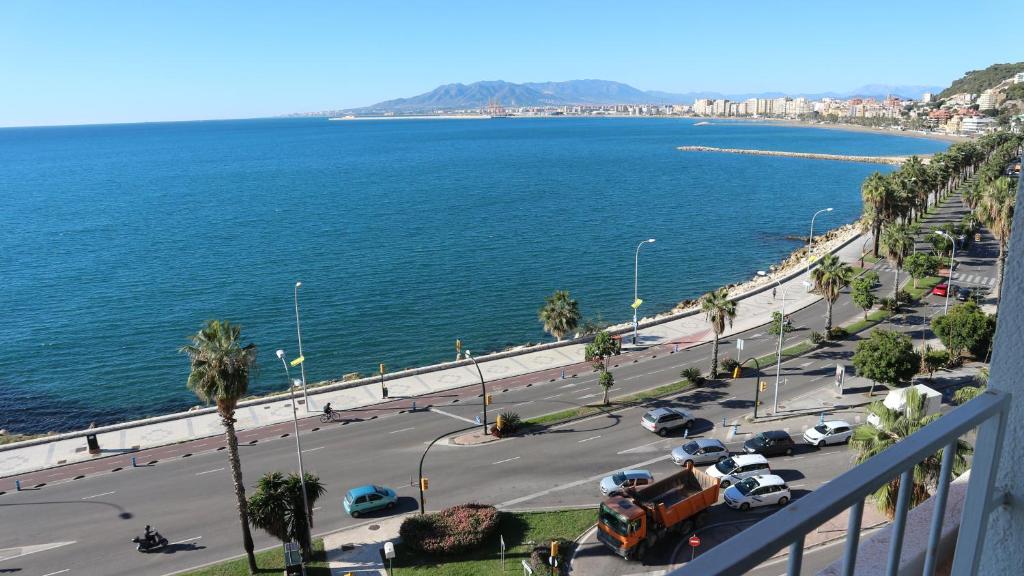 uma vista para uma rua com carros e o oceano em Apartamento Frente Al Mar em Málaga