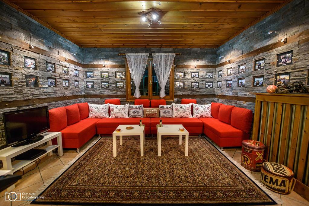 a living room with a red couch and a tv at Traditional Guesthouse in Tríkala