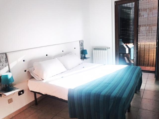 - une chambre dotée d'un grand lit blanc avec des draps bleus dans l'établissement Le case di Pone, à Cologno Monzese