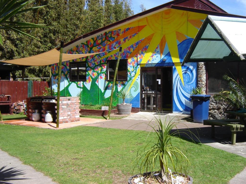 a building with a colorful mural on the side of it at Ahipara Holiday Park in Ahipara
