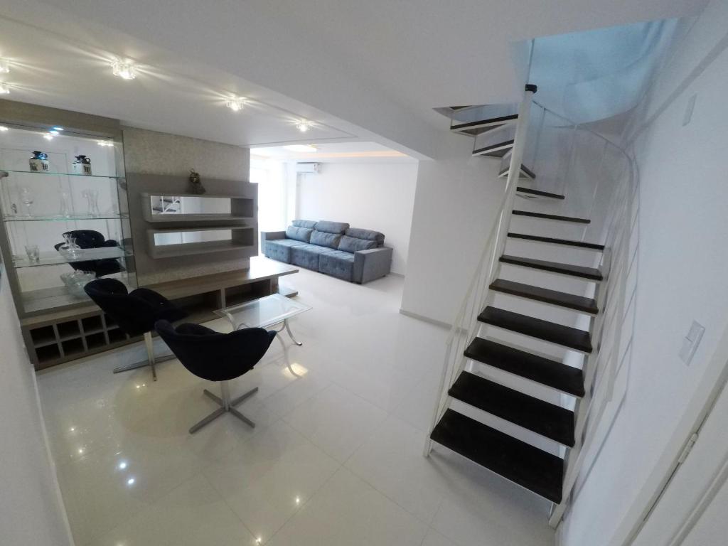 sala de estar con escalera y silla en A075 - Ed. Mônica, cobertura duplex, en Bombinhas