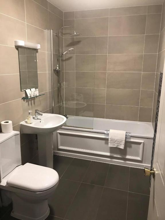 a bathroom with a toilet and a tub and a sink at Bridge of Orchy Hotel in Bridge of Orchy
