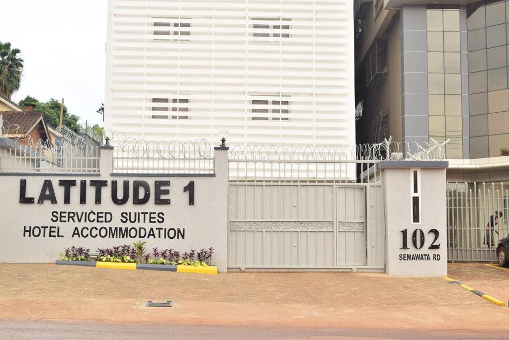 a white building with a sign that reads furniture served suites hotel accommodation at Latitude 1 Suites in Kampala