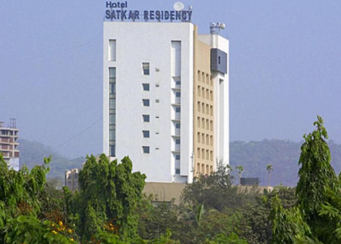 ein großes weißes Gebäude mit einem Schild darüber in der Unterkunft Hotel Satkar Residency in Thane