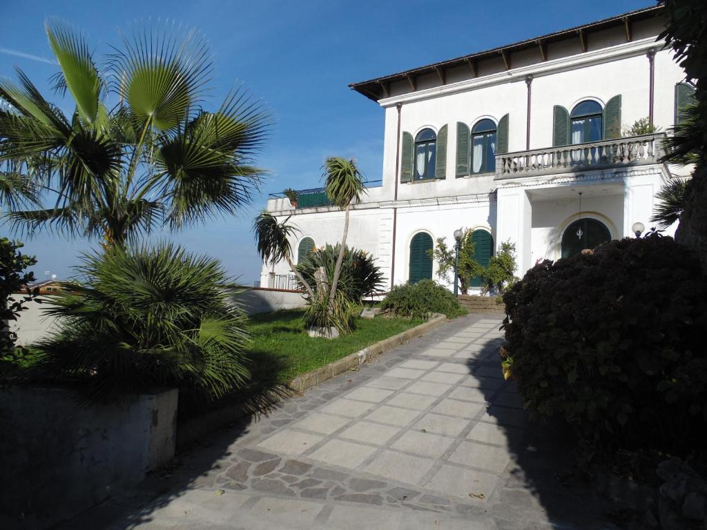 uma casa branca com uma palmeira em frente em Villa Bianca em Castellammare di Stabia