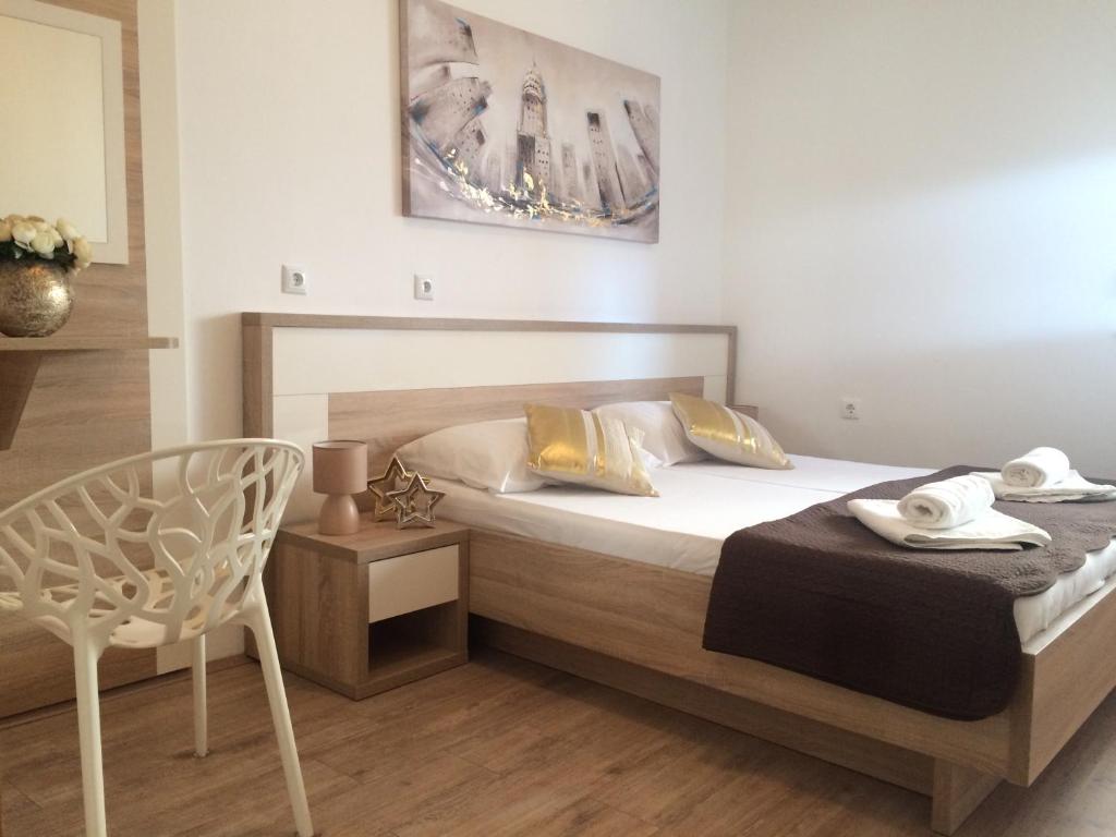 a bedroom with a bed and a chair in it at Apartmani Emilio Novalja in Novalja