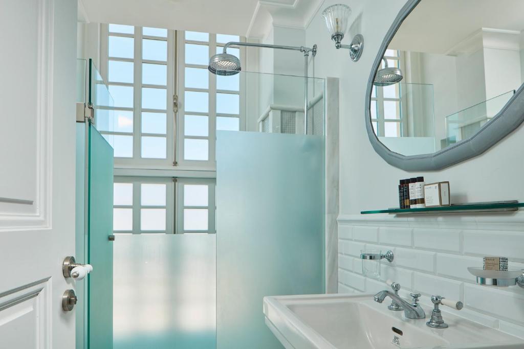 a bathroom with a shower and a sink and a mirror at Poseidonion Grand Hotel in Spetses