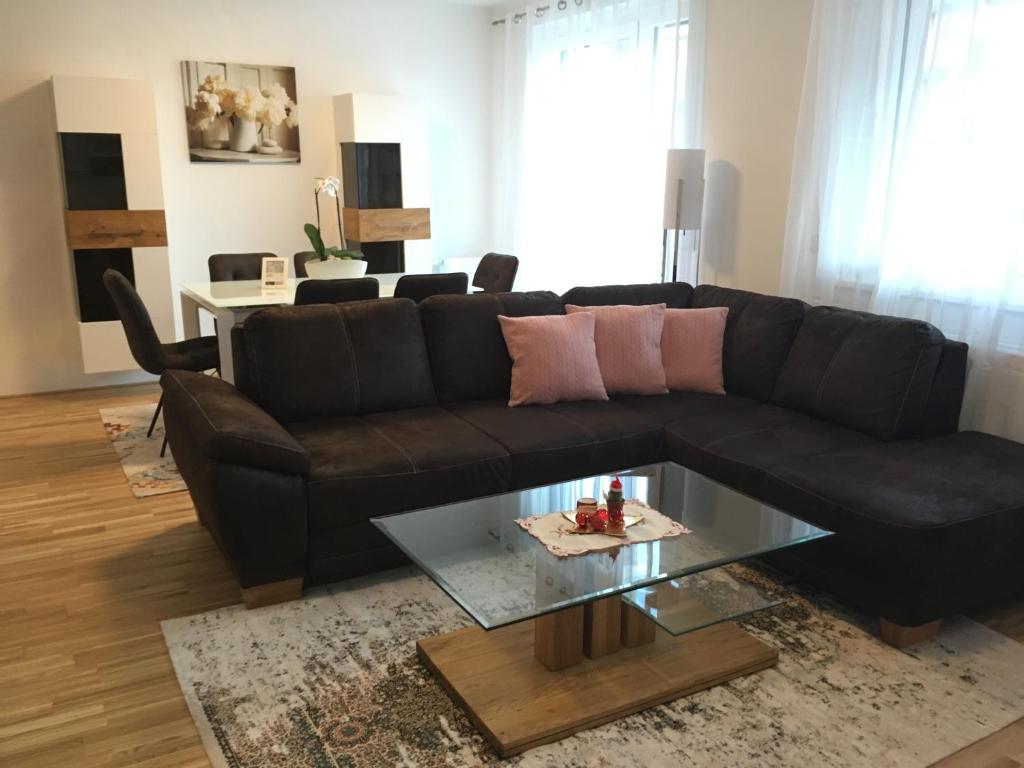 salon z czarną kanapą i szklanym stołem w obiekcie New Stylish Apartment w Wiedniu