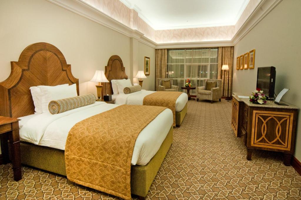 a hotel room with two beds and a television at Ayla Hotel in Al Ain