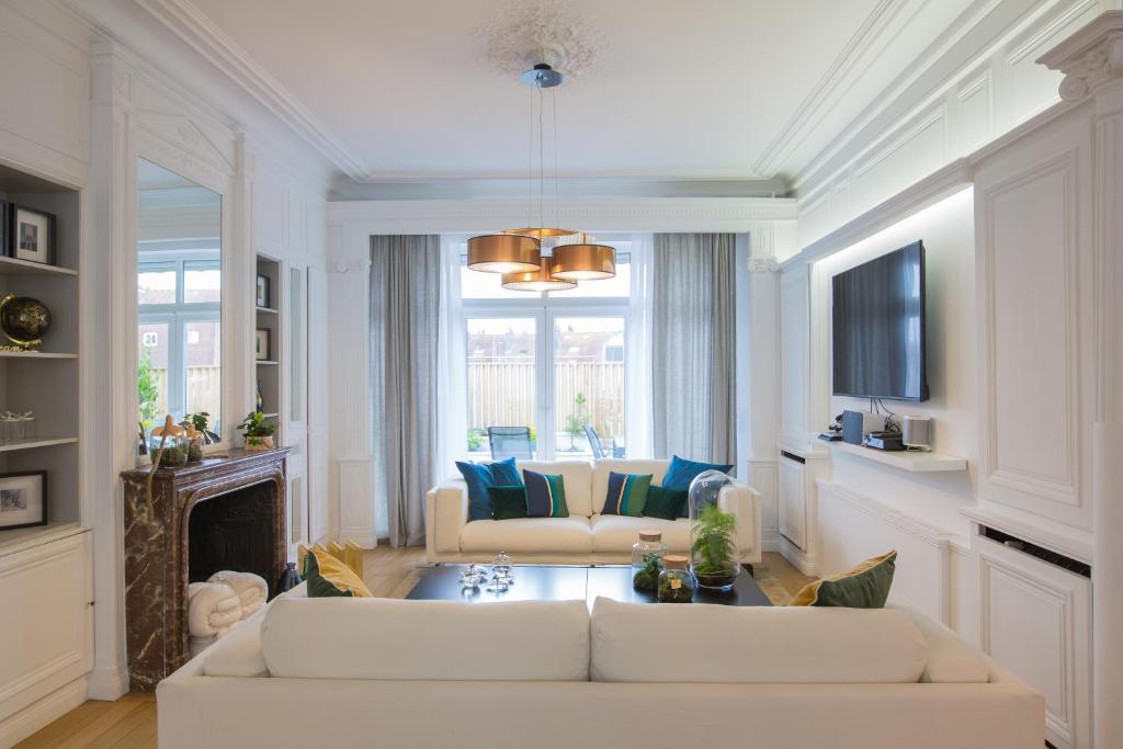 a living room with two white couches and a fireplace at Luxueux logement Bourgeois de 250 M2 climatisé in Lille