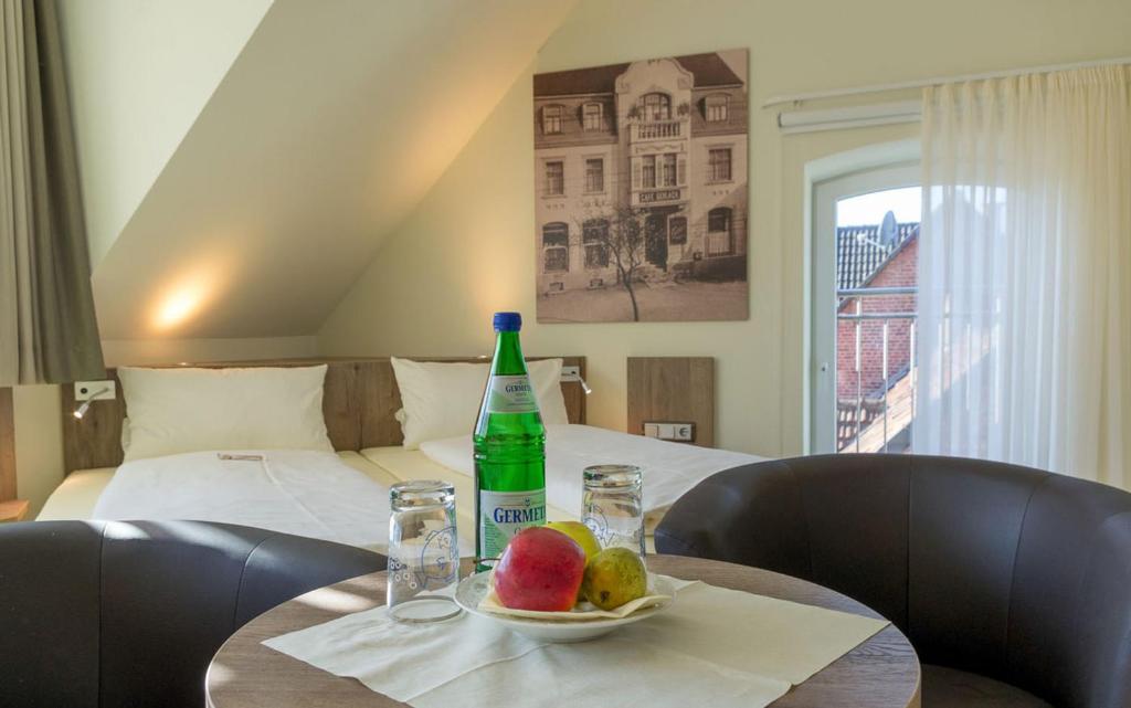 una mesa con una botella de agua y un plato de fruta en Zeitlers Hotel en Marsberg