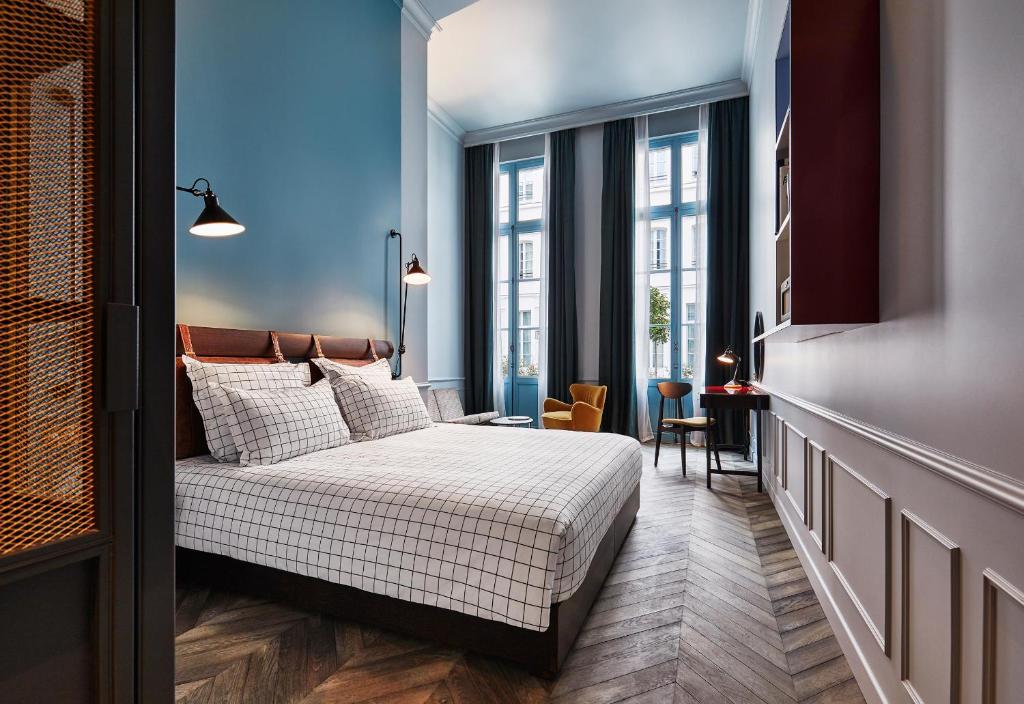 a bedroom with a bed and a large window at The Hoxton, Paris in Paris