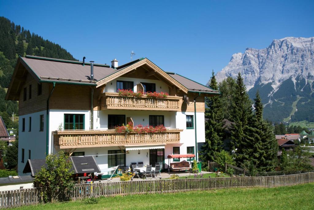 a house with a balcony and mountains in the background at Haus Gipfelblick in Lermoos