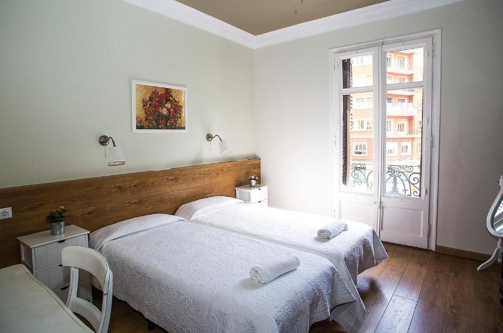 2 Betten in einem weißen Zimmer mit Fenster in der Unterkunft Mai & Maud Paralel Apartment in Barcelona