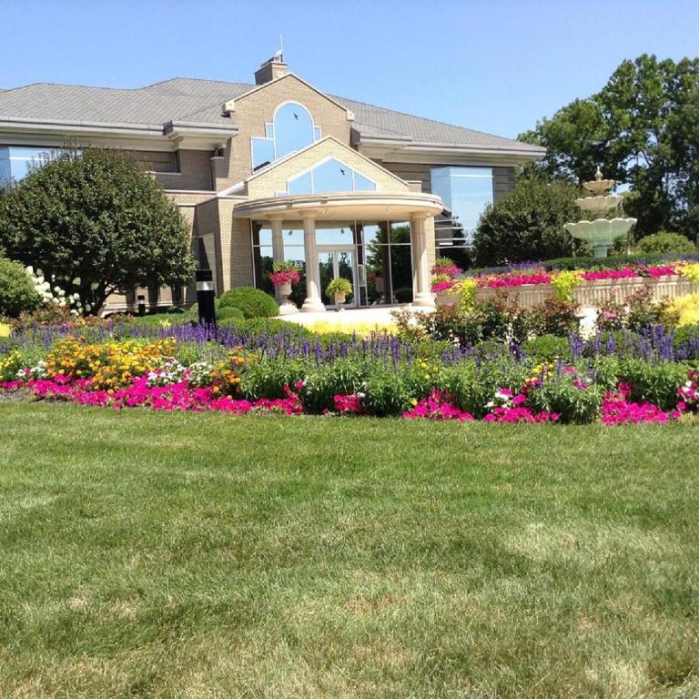 a house with a garden of flowers in the yard at Mill Creek Gardens in Winamac