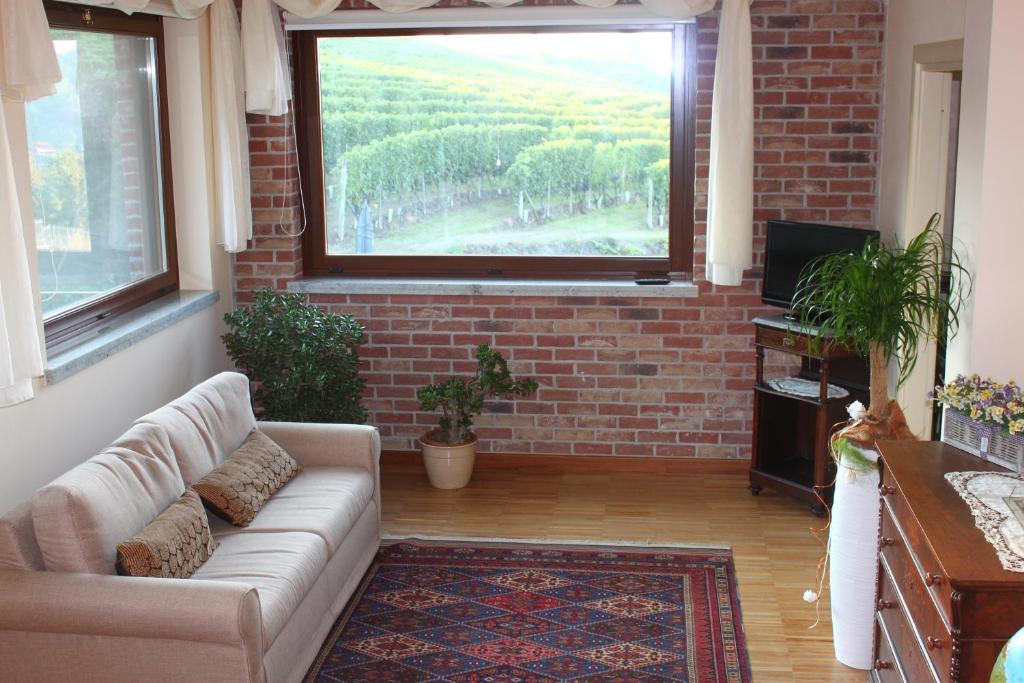 un soggiorno con divano e una grande finestra di Villa Vecchio a Castagnito