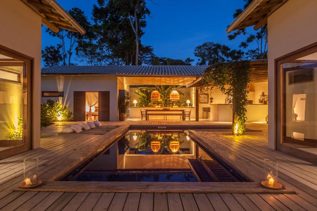 una piscina al aire libre con terraza y una casa en Casa Biri-Biri, en Trancoso