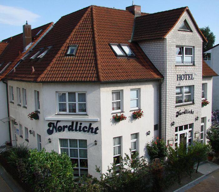 een wit gebouw met een bord voor een hotel bij Hotel Nordlicht in Schwerin