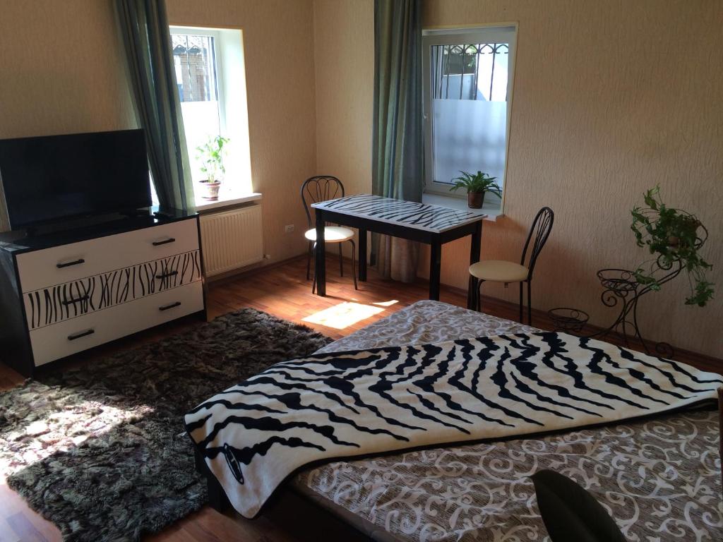 una camera con letto, televisore e tavolo di Апартаменты a Izmaïl