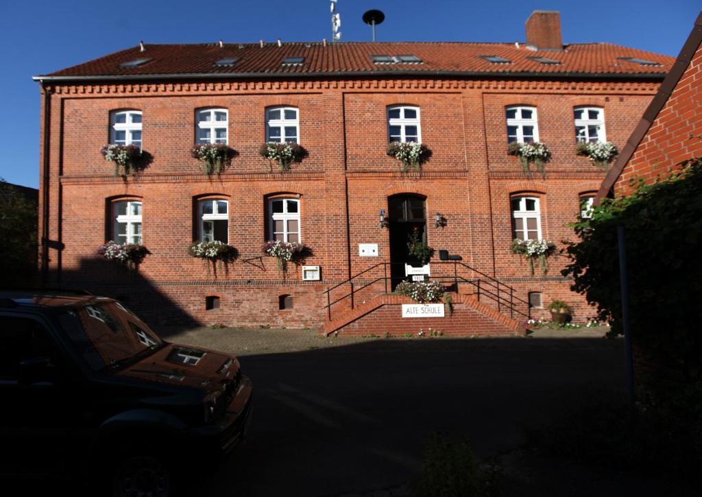 a large red brick building with white windows at Alte Schule Schnackenburg in Schnackenburg
