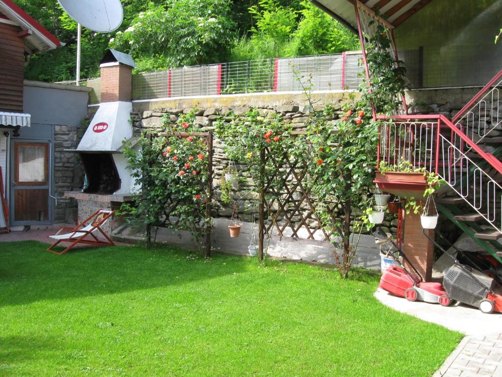 a garden with two trees and a stone wall at Pensiunea Amo in Vălenii de Munte