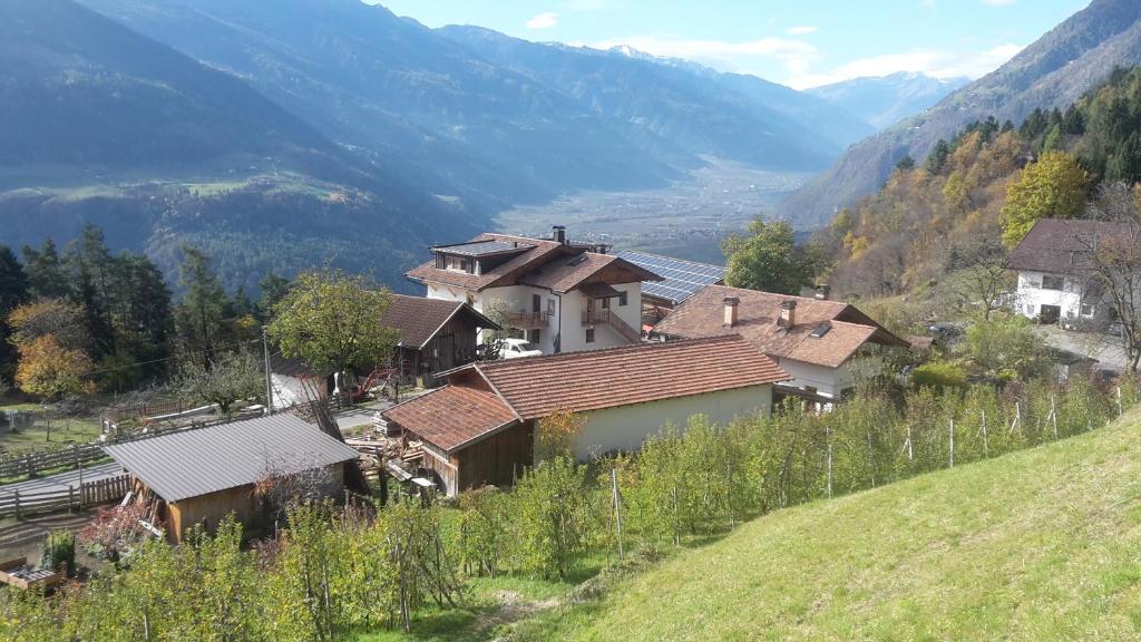 um grupo de casas numa colina com montanhas ao fundo em Gruberhof em Lagundo