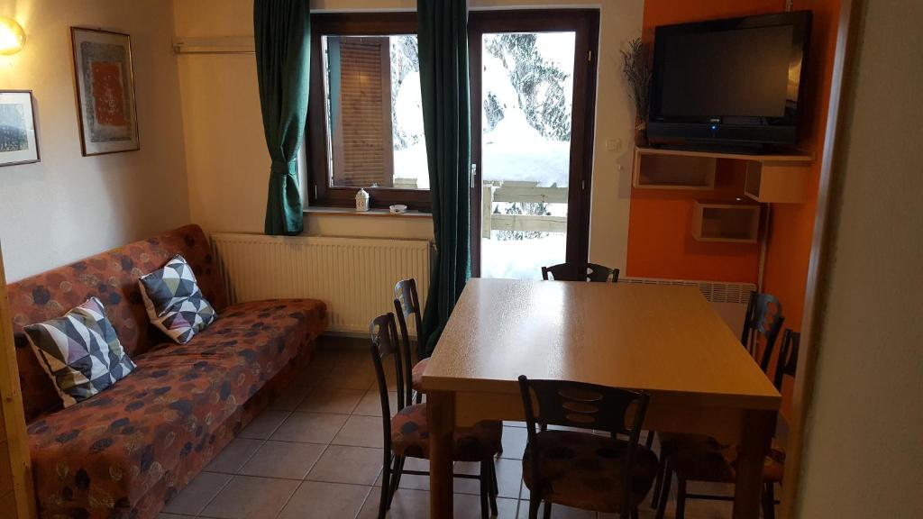 a living room with a couch and a table at Rogla app Jerebika 11 in Zreče