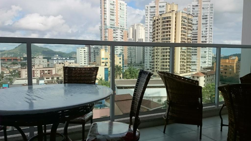 a table and chairs on a balcony with a view of a city at Studio mobiliado in Santos