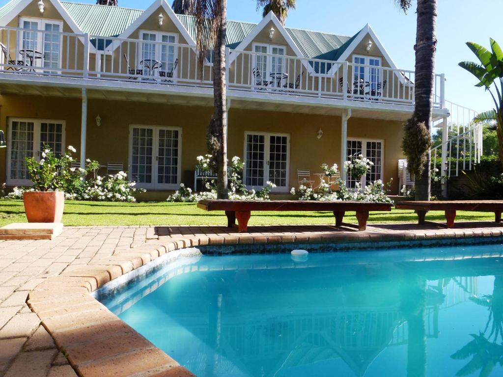 une maison avec une piscine en face d'une maison dans l'établissement @Yamkela Guest House, à Oudtshoorn