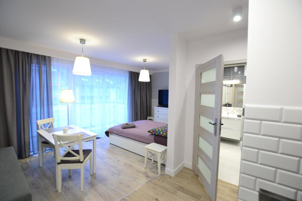 een kamer met een eettafel en een slaapkamer bij Darłówko Apartament Morski II in Darlowko