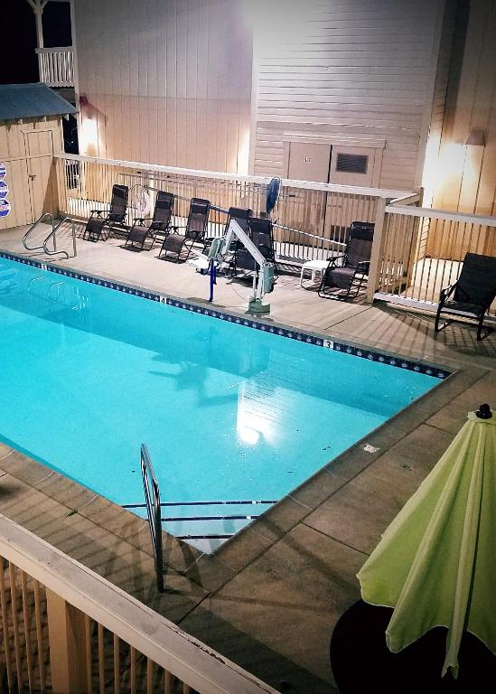 a large swimming pool with chairs around it at Travelodge by Wyndham Angels Camp CA in Angels Camp