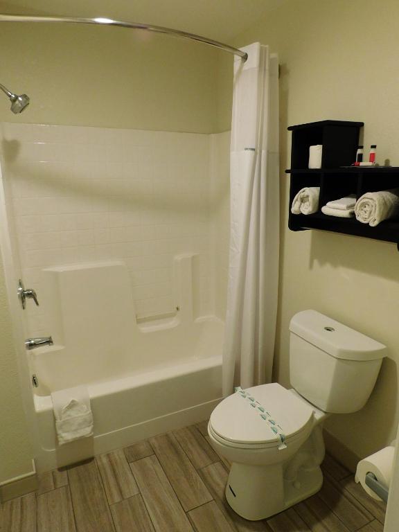 a bathroom with a white toilet and a bath tub at Travelodge by Wyndham Angels Camp CA in Angels Camp