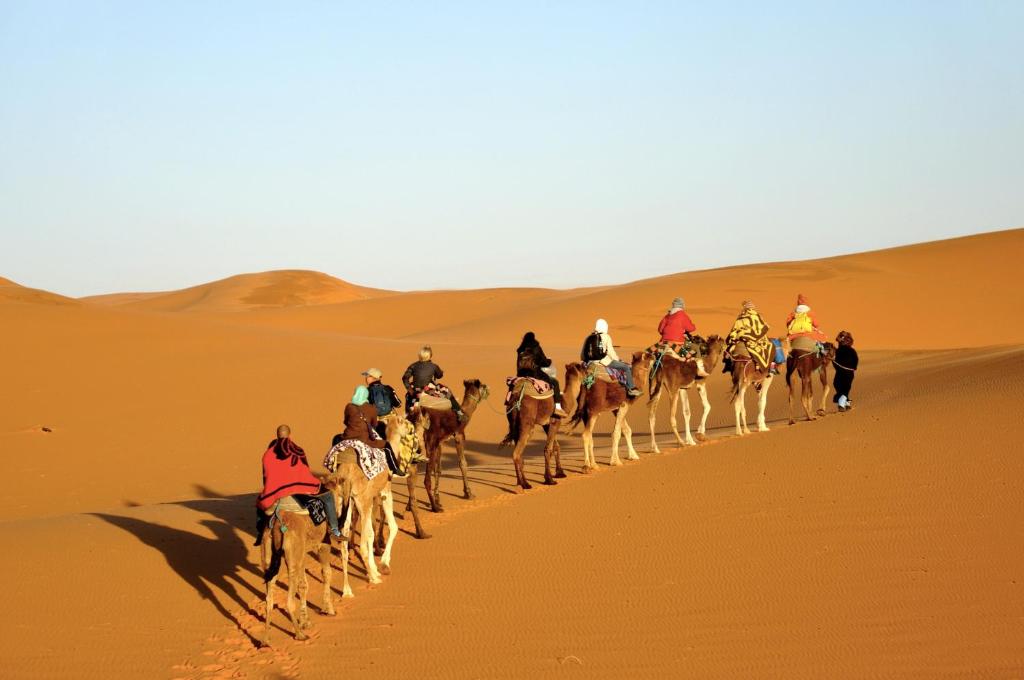 un groupe de personnes à cheval dans le désert dans l'établissement Sahara camel tours camp, à Merzouga