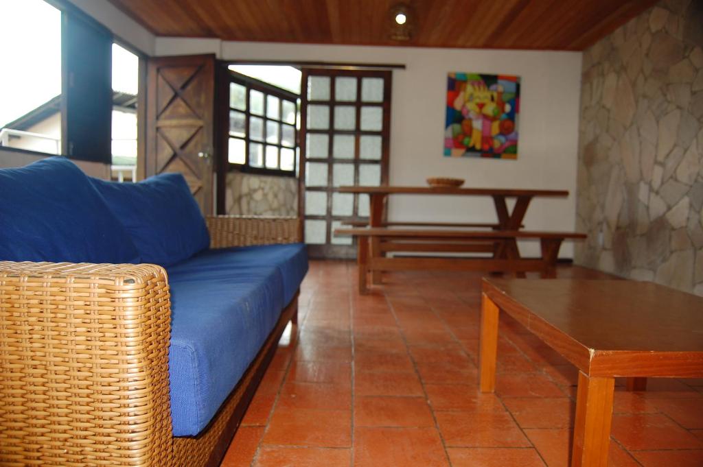 sala de estar con sofá azul y mesa en Casa do Frá, en Morro de São Paulo