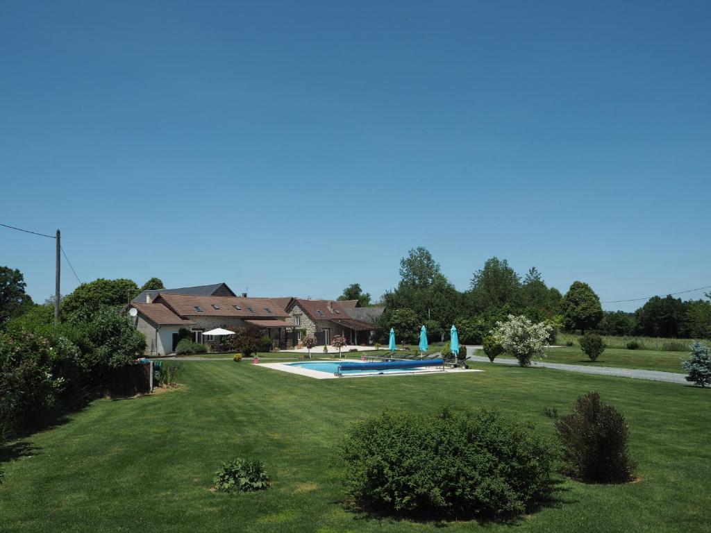 a yard with a swimming pool and a house at Villas de Leypinas Gites in Saint-Pardoux-Corbier