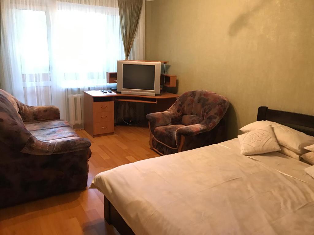 ヴィーンヌィツャにあるBeautiful Apartment on Korolenka 31のベッドルーム1室(ベッド1台、椅子2脚、テレビ付)