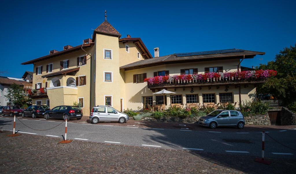 een groot gebouw met auto's geparkeerd voor het bij Gasthof Zur Sonne in Laion