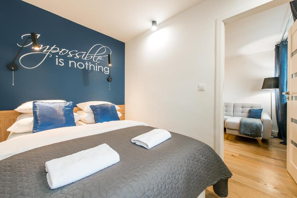 a bedroom with a bed with blue and white pillows at P&O Apartments Śliska in Warsaw