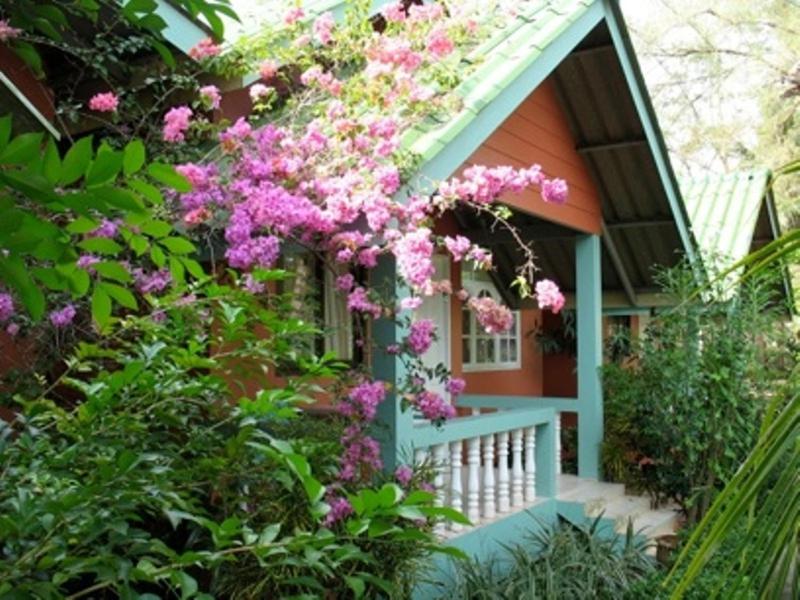 a house with pink flowers on the side of it at Mairood Resort in Ban Mai Rut