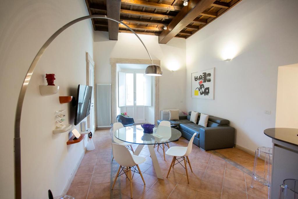 a living room with a table and a couch at Pgrhome Luxury Apartments Domus Pantheon in Rome