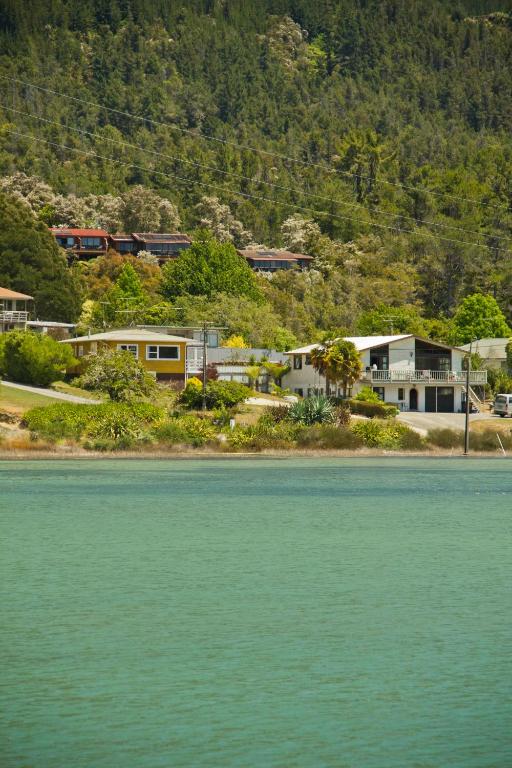 un gruppo di case su una collina vicino all'acqua di Abel Tasman Kaiteriteri B & B a Kaiteriteri